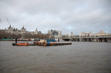 LONDON, UNITED KINGDOM - 30 ARALIK 2017: Thames Nehri önplanda işbotları ve mavnalarıyla, ve arka planda Hungerford Köprüsü ve tarihi binaları içeren Westminster 'ın ufuk çizgisi