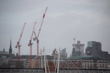 LONDRA, BİRLİK KINGDOM - 30 ARALIK 2017: Bulutlu gökyüzü altında inşaat vinçleri ve şehir mimarisi ile şehir silueti. Yüksek kalite fotoğraf