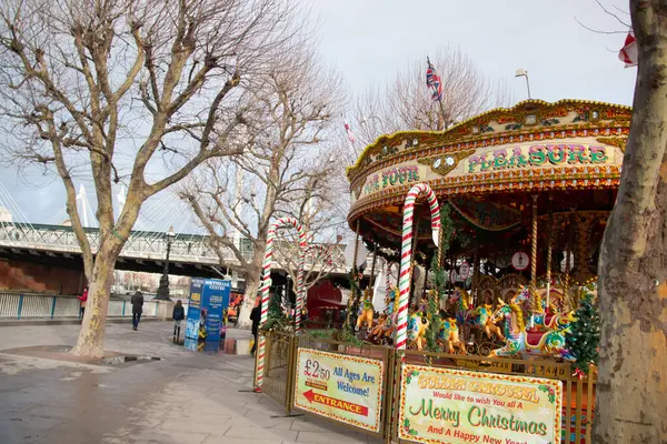 Londra, BİRLİK KINGDOM - 30 ARALIK 2017: Thames Nehri 'nin güney kıyısında kış ağaçları ve yoldan geçen insanlar için şenlikli klasik bir atlıkarınca. Yüksek kalite fotoğraf