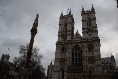 30 Aralık 2017 'de Westminster Abbey' in dış görünüşü dramatik bulutlu gökyüzü ile gotik mimariyi ve yükselen bir savaş anıtı sütununu gösteriyor. Yüksek kalite fotoğraf