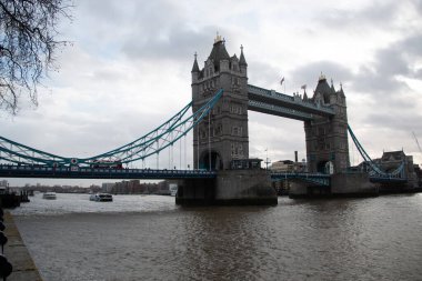 Londra, ENGLAND - 30 Aralık 2017: Tower Bridge, Thames Nehri 'ni bulutlu bir kış günü, güneydeki kıyıdan su üzerinde tekneleri ve bulutlu bir gökyüzü ile kaplar. Yüksek kalite fotoğraf