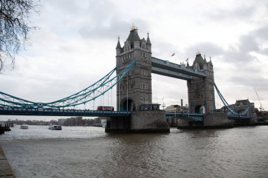 30 Aralık 2017 'de bulutlu gökyüzü ve kışın liman boyunca yürüyen insanlarla Thames Nehri üzerindeki Tower Bridge manzarası. Yüksek kalite fotoğraf