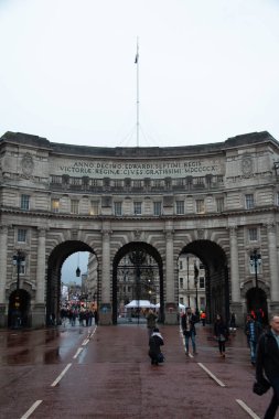 LONDON, UNITED KINGDOM - 23 Aralık 2017: Yağmurlu bir günde yayalar ve bisikletçiler kemerlerin altından geçerken AVM 'den görülen Amirallik Kemeri. Yüksek kalite fotoğraf