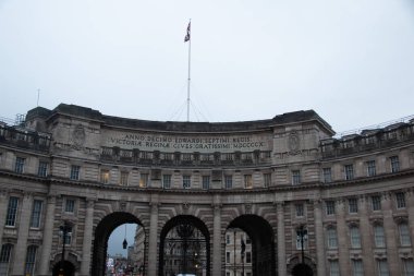 LONDON, UNITED KINGDOM - 23 ARALIK 2017: Londra 'nın orta kesimindeki Deniz Kuvvetleri Kemeri' nin tarihi kemerlerinin altında bulutlu bir kış gökyüzü altında yürüyen yayalar ile ön görüntüsü. Yüksek kalite fotoğraf