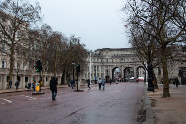 LONDON, UNITED KINGDOM - 23 Aralık 2017: Yayalar Londra 'nın merkezindeki AVM boyunca çıplak ağaçlar ve tarihi binalar tarafından çerçevelenmiş bir kış günü AVM' ye doğru yürürler. Yüksek kalite fotoğraf