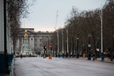 LONDON, BİRLİK KINGDOM - 23 ARALIK 2017: Soğuk bir kış günü, Buckingham Sarayı ve Victoria Anıtı 'na uzak bir manzara, yol boyunca çıplak ağaçlar ve az sayıda yayayla kaplı