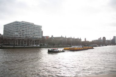 LONDON, UNITED KINGDOM - 30 ARALIK 2017: Bulutlu bir kış gününde nehir kenarındaki modern binalar ve demirlemiş teknelerle Thames Nehri 'nin manzarası. Yüksek kalite fotoğraf