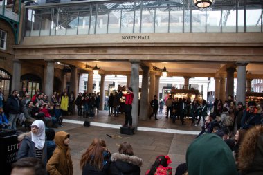 LONDON, UNITED KINGDOM - 30 Aralık 2017: Bir sokak sanatçısı, Covent Garden Market 'in Güney Salonu' nda bir kalabalığı eğlendiriyor.