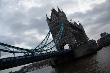 Londra, UNITED KINGDOM - 30 Aralık 2017: Tower Bridge, Thames Nehri üzerinde bulutlu bir kış gökyüzünün altında köprülerin simetrik kulelerini ve donuk süspansiyon elementlerini sergiliyordu. Yüksek