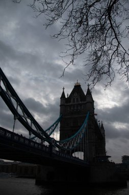 Londra, UNITED KINGDOM - 30 Aralık 2017: Tower Bridge, Thames Nehri üzerinde bulutlu bir kış gökyüzünün altında köprülerin simetrik kulelerini ve donuk süspansiyon elementlerini sergiliyordu. Yüksek