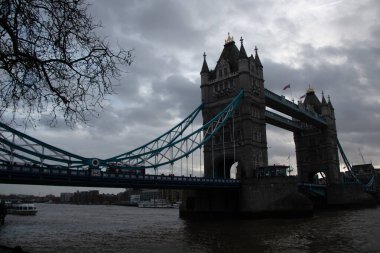 Londra, UNITED KINGDOM - 30 Aralık 2017: Tower Bridge, Thames Nehri üzerinde bulutlu bir kış gökyüzünün altında köprülerin simetrik kulelerini ve donuk süspansiyon elementlerini sergiliyordu. Yüksek