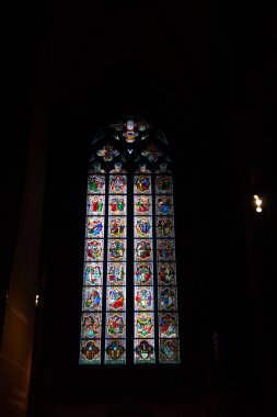 COLOGNE, ALMANY - 29 Aralık 2017 Köln Katedrali 'nin karanlığında parlayan izole cam pencere Gotik çerçevede canlı dini imgeleri vurguluyor. Yüksek kalite fotoğraf