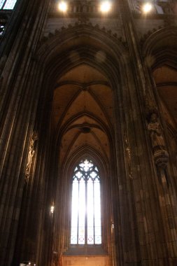 COLOGNE, GERMANY - 29 Aralık 2017: Yükselen Gotik kemerler ve Köln katedrallerinin görkemli sütunları, uzun vitray pencerelerden süzülen doğal ışıkla hafifçe aydınlatılıyor. Yüksek
