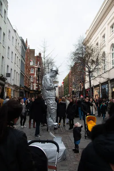 Londra, İngiltere - 30 Aralık 2017: Covent Garden 'da kalabalık bir kış gününde heykel sokak sanatçısı kalabalığı eğlendiriyor. Yüksek kalite fotoğraf
