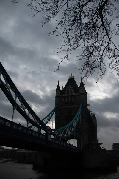Londra, UNITED KINGDOM - 30 Aralık 2017: Tower Bridge, Thames Nehri üzerinde bulutlu bir kış gökyüzünün altında köprülerin simetrik kulelerini ve donuk süspansiyon elementlerini sergiliyordu. Yüksek