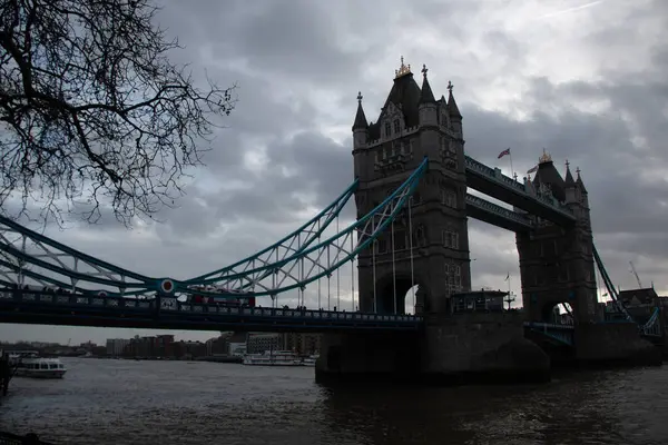 Londra, UNITED KINGDOM - 30 Aralık 2017: Tower Bridge, Thames Nehri üzerinde bulutlu bir kış gökyüzünün altında köprülerin simetrik kulelerini ve donuk süspansiyon elementlerini sergiliyordu. Yüksek