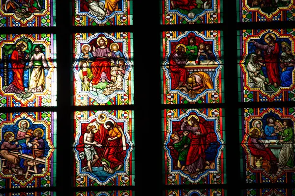 COLOGNE, ALMANY - 29 Aralık 2017: Köln Katedrali 'nin içindeki karmaşık boyalı cam panellere yakın çekim, İncil' deki canlı sahneler ve yumuşak ortam ışığı altında Gotik desenler sergiliyor. Yüksek