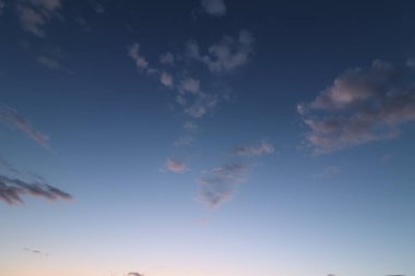 Alacakaranlıkta sakin bir gökyüzü, dağınık bulutlar ve akşam ışığında yumuşak renkler. Yüksek kalite fotoğraf