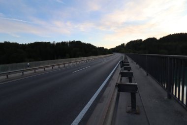 WASSERBURG AM Hanı, ALMANY - 19 Mayıs 2025 Wasserburg yakınlarındaki Innbruecke köprüsünün akşam manzarası ve uzak tepeler ve günbatımı gökyüzü. Yüksek kalite fotoğraf