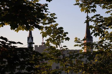WASSERBURG AM Hanı, ALMANY - 30 Mayıs 2025: Frauenkirche 'in akşam silueti ve Wasserburg am Inn' deki Heilig-Geist-Spital kilise kulesi Inn Nehri 'nin karşısındaki güney nehir kıyısından görüldü. Yüksek