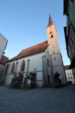 WASSERBURG AM Hanı, GERMANY - 30 Mayıs 2025: Frauenkirche kilisesinin kırmızı çatısı ve eski kasabadaki tarihi binalarla çevrili tüm cephe manzarası. Yüksek kalite fotoğraf