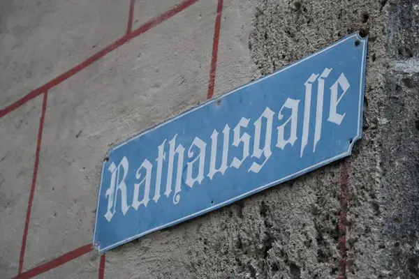WASSERBURG AM Hanı, GERMANY - 30 Mayıs 2025: Eski tarihi kentteki taş bir duvara asılmış Rathausgasse yazan mavi sokak tabelasının yakın çekimi. Yüksek kalite fotoğraf
