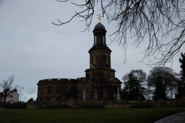 SHREWSBURY, UNITED KINGDOM - 2 Ocak 2018: St Chads Kilisesi 'nin yuvarlak kulesi Shrewsbury' deki bulutlu bir gökyüzünün altındaki kış ağaçlarının arasından görülüyor. Yüksek kalite fotoğraf