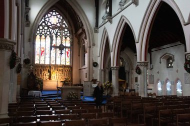 SHREWSBURY, UNITED KINGDOM - 2 HAZİRAN 2018: Shrewsbury 'deki St Alkmunds Kilisesi ahşap sıraları, kemerli kolonları ve sunağın üzerinde bir vitraylı pencereyi gösteriyor. Yüksek kalite fotoğraf