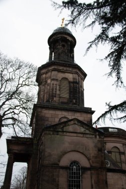 SHREWSBURY, UNITED KINGDOM - 2 HAZİRAN 2018: Bulutlu bir kış gününde Shrewsbury 'deki ağaçlar tarafından kısmen çerçevelenen St Chads Kilisesi ve kubbesinin dikey manzarası. Yüksek kalite fotoğraf