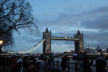 Londra 'nın merkezinde alacakaranlıkta Thames nehri boyunca yayalar ve mavi gökyüzü ile Tower Bridge' in akşam manzarası. Yüksek kalite fotoğraf