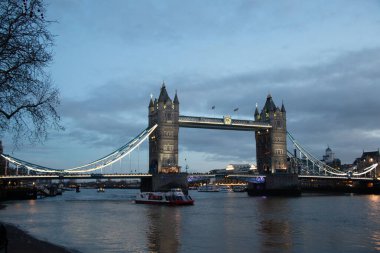 LONDON, UNITED KINGDOM - 1 HAZİRAN 2018: alacakaranlıkta Thames Nehri 'ndeki teknelerle aydınlanan Tower Bridge ve Londra' nın merkezindeki suya yansıyan yansımalar. Yüksek kalite fotoğraf