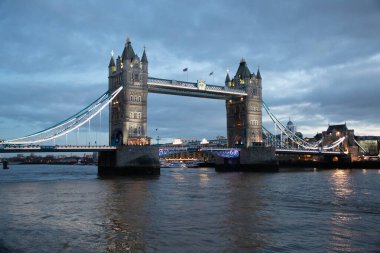 LONDON, UNITED KINGDOM - 1 HAZİRAN 2018: Alacakaranlıkta aydınlanan Kule Köprüsü Thames Nehri 'nin yansımaları ve Londra' nın merkezinde bulutlu gökyüzü. Yüksek kalite fotoğraf