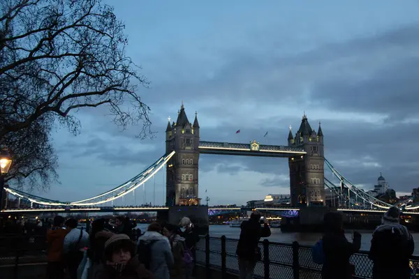 Londra 'nın merkezinde alacakaranlıkta Thames nehri boyunca yayalar ve mavi gökyüzü ile Tower Bridge' in akşam manzarası. Yüksek kalite fotoğraf