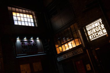 LONDON, UNITED KINGDOM - 1 HAZİRAN 2018: Endüstriyel pencereli tuğla bir binada, Gurme Burger Mutfak 'ın aydınlanmış yüzü. Yüksek kalite fotoğraf