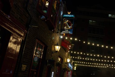 LONDON, UNITED KINGDOM - 1 HAZİRAN 2018: Southwark 'taki The Anchor Pub' ın gece görüşü, bir tuğla cephesinde asılı fenerler, sicim lambaları ve geleneksel İngiliz tabelasıyla. Yüksek kalite fotoğraf