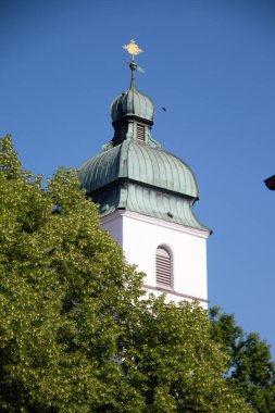 EBERSBERG, GERMANY - 8 Mayıs 2018: Ebersberg 'deki yeşil ağaçların üzerinde yükselen Katolik kilisesinin barok kilise kulesinin manzarası. Yüksek kalite fotoğraf