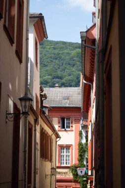 Heidelberg 'deki eski dar sokaklar, arka plandaki tepelere doğru bakan geleneksel binalar tarafından çerçevelenmiştir. Yüksek kalite fotoğraf