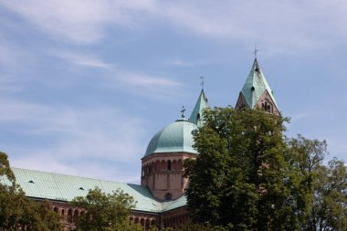SPEYER, ALMANY - 21 Mayıs 2018: mavi gökyüzünün altındaki ağaçlar tarafından kısmen gizlenmiş Speyer Katedrallerinin turkuaz kubbeleri ve kuleleri. Yüksek kalite fotoğraf