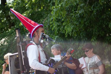 SPEYER, GERMANY - 21 Mayıs 2018: Bir kalabalığın önünde canlı performans sırasında kostümlü sokak müzisyeni bir hoparlörle gitar çalıyor. Yüksek kalite fotoğraf