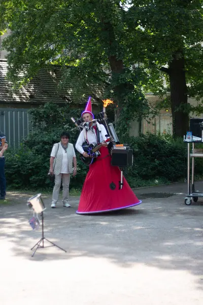 SPEYER, ALMANY - 21 Mayıs 2018: renkli kostümlü sokak göstericisi ve Speyer Katedrali 'nin yakınındaki gölgeli bir halk meydanında misafir ağırlıyor. Yüksek kalite fotoğraf