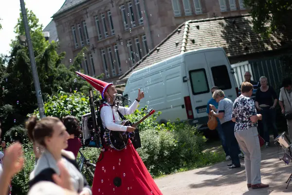 SPEYER, ALMANY - 21 Mayıs 2018: Geleneksel kostümlü kadın stilt walker katedral meydanının yakınındaki bir sokak gösterisinde kalabalığı eğlendiriyor. Yüksek kalite fotoğraf