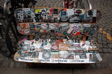 LEIPZIG, ALMANY - 18 Ağustos 2018: Leipzig 'de şehir merkezinde renkli çıkartmalar ve graffitilerle kaplı bir bankın yakın çekimi. Yüksek kalite fotoğraf