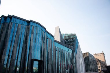 LEIPZIG, ALMANY - 18 Ağustos 2018: Augustusplatz 'daki Paulinum üniversite binasının modern cam cephesinin düşük açılı görüntüsü. Yüksek kalite fotoğraf
