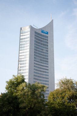 LEIPZIG, ALMANY - 18 Ağustos 2018: Şehir-Hochhaus gökdeleni, ağaçların üzerinde yükselen modern bir yapı. Yüksek kalite fotoğraf