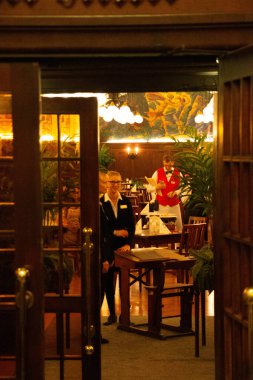 LEIPZIG, ALMANY - 18 Ağustos 2018: Geceleri ahşap masaları ve sandalyeleri olan geleneksel bir restoranın sıcak ve samimi iç mekanı. Yüksek kalite fotoğraf