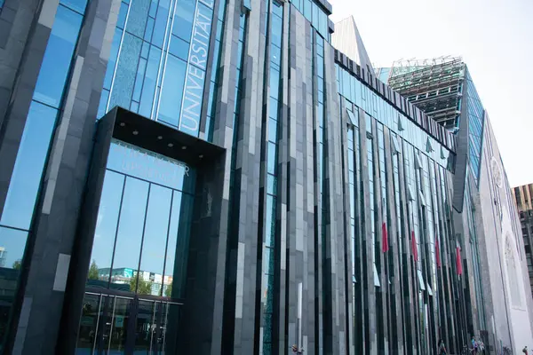 LEIPZIG, GERMANY - 18 Ağustos 2018: Leipzig Üniversitesi 'ndeki Paulinum binasının modern cam cephesi gökyüzünü ve çevreyi yansıtıyor. Yüksek kalite fotoğraf