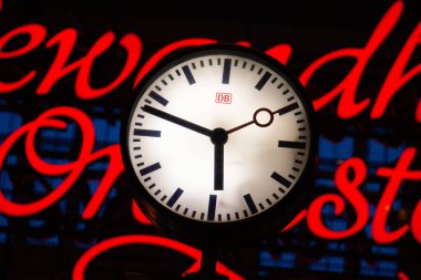  LEIPZIG, ALMANY - 18 AĞUSTOS 2018: Bulanık neon ışığın önündeki Deutsche Bahn tren istasyonu saati. Yüksek kalite fotoğraf