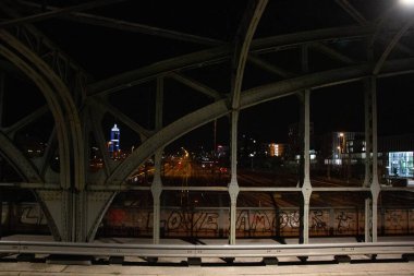 Münih 'teki Hackerbruecke demiryolu köprüsünün ön planda şehir ışıkları ve metal yapılarla gece görüşü. Yüksek kalite fotoğraf