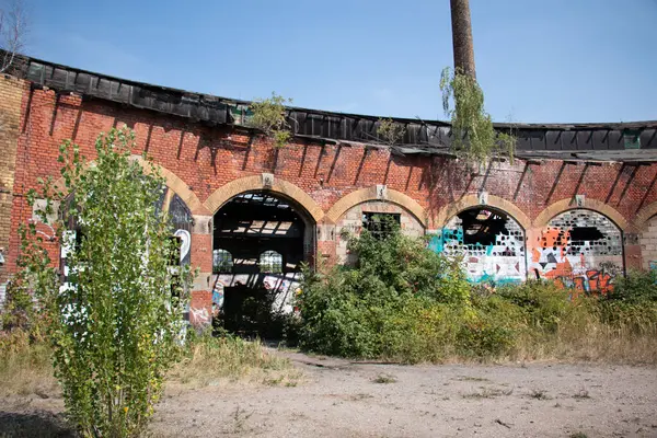  LEIPZIG, GERMANY - 19 Ağustos 2018: Alter Postbahnhof 'un dış görünüşü, kemerli pencereleri ve graffitisi olan terk edilmiş bir sanayi binası. Yüksek kalite fotoğraf