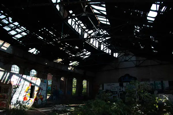 LEIPZIG, GERMANY - 19 AĞUSTOS 2018: Leipzig 'deki terk edilmiş posbahnhof' un çatısı çökmüş, fazla gelişmiş bitkiler ve duvarlara grafiti yapılmış iç mimarisi